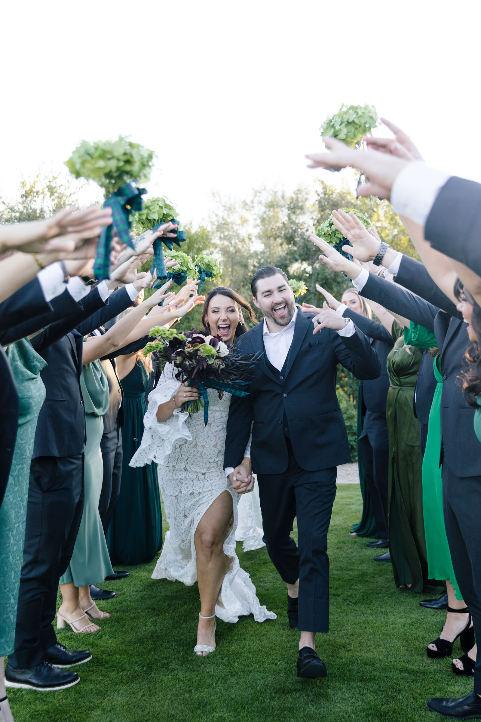 Bride and groom running through bridal party tunnel cheering them on at the Paradise Valley Country Club in Arizona